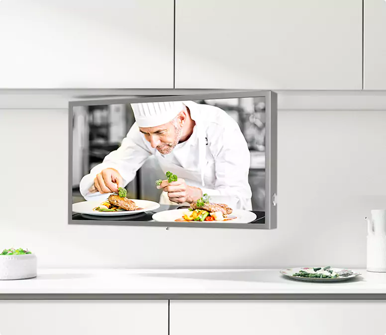 Brushed stainless steel-framed kitchen TV beneath a white floating cabinet.