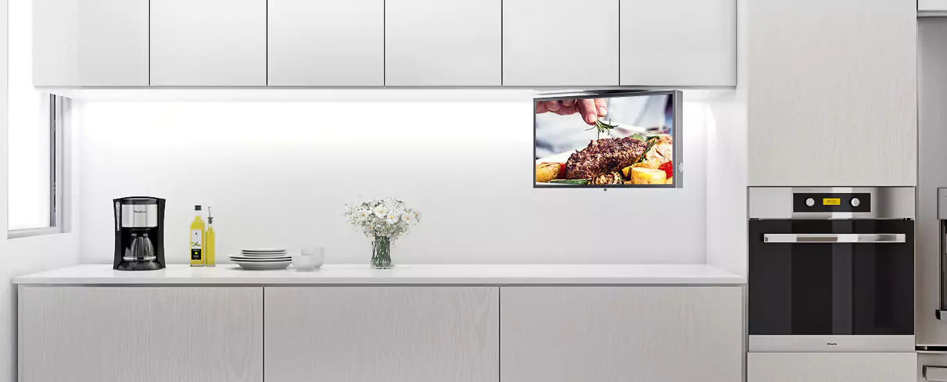 White-walled chef's domain with a kitchen TV underneath an overhead shelf cabinet.